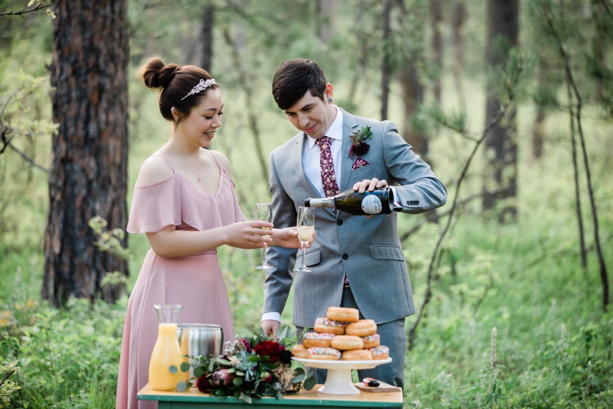 Groom pouring champagne for his new wife during their wedding ceremony in the Black Hills.