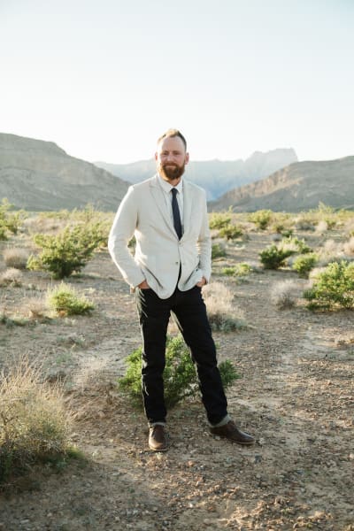 A full body portrait of a groom posing in the late afternoon sun in the Mojave Desert outside Las Vegas.
