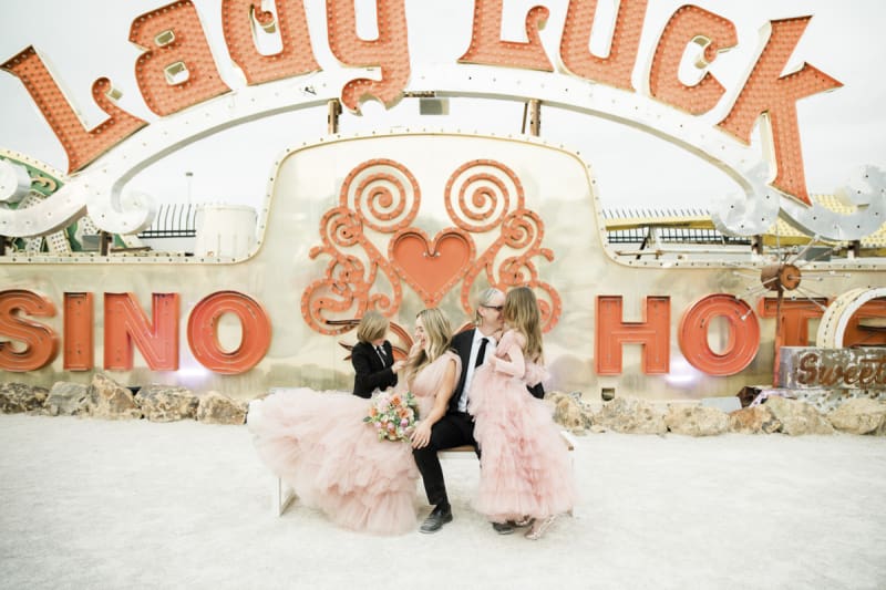 The retired neon sign from the Lady Luck Hotel and Casino acts as a backdrop for wedding day photos of a couple, their son and their daughter at the Neon Museum in Las Vegas.