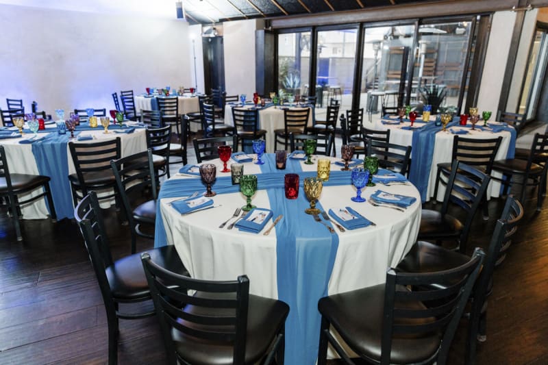 The main room and courtyard at Forge Social House is set with tables and chairs for a wedding reception.