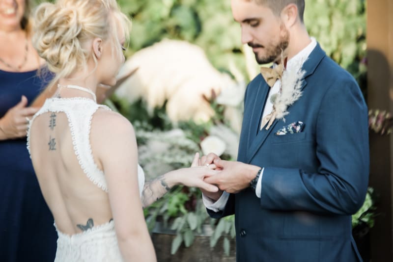 Groom placing finger on bride at wedding ceremony.