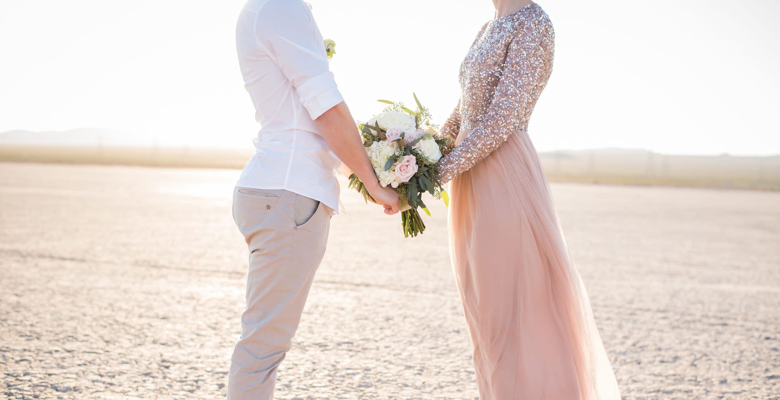 Couple joined by wedding bouquet.