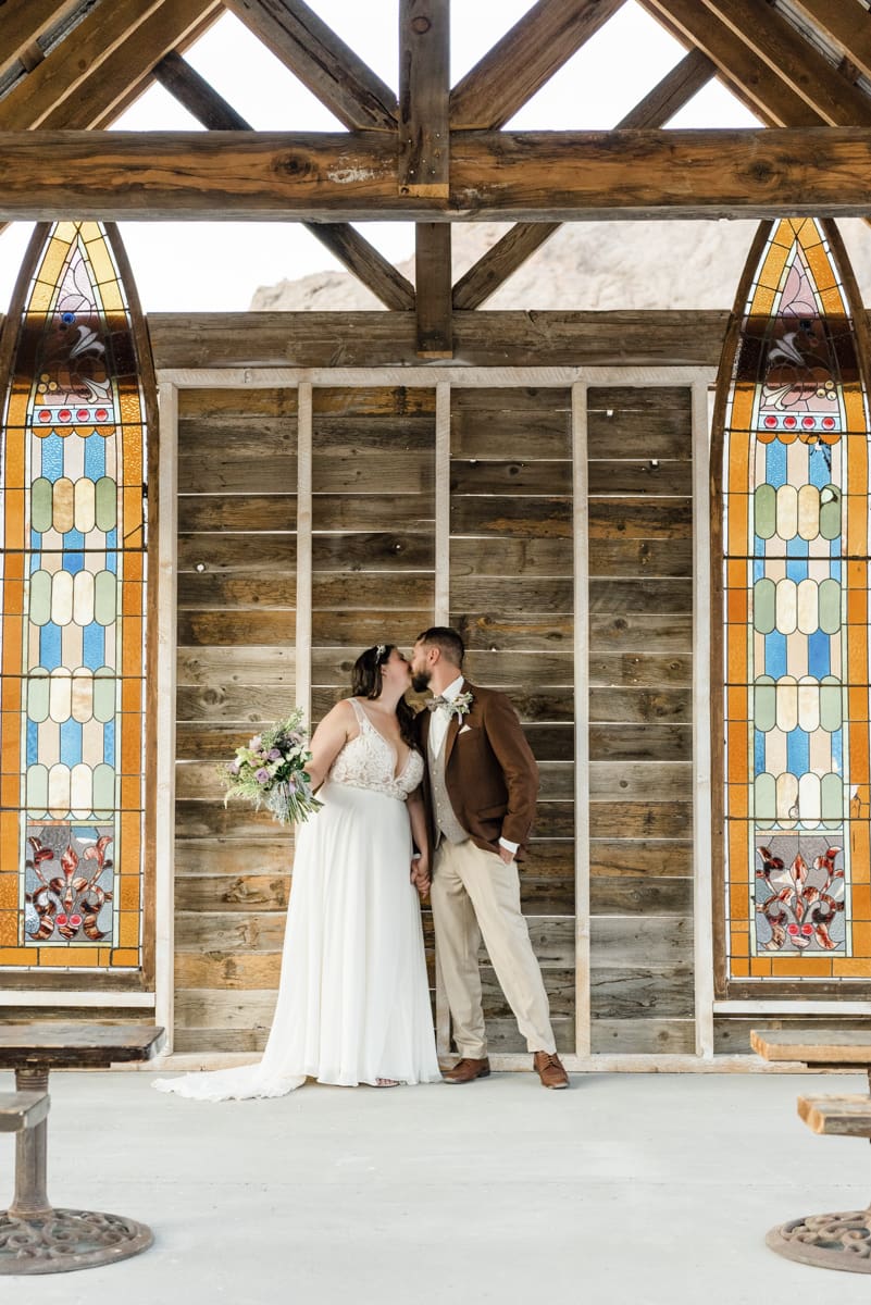 Groom and bride sharing a kiss inside the Eldorado Canyon wedding chapel in Las Vegas.