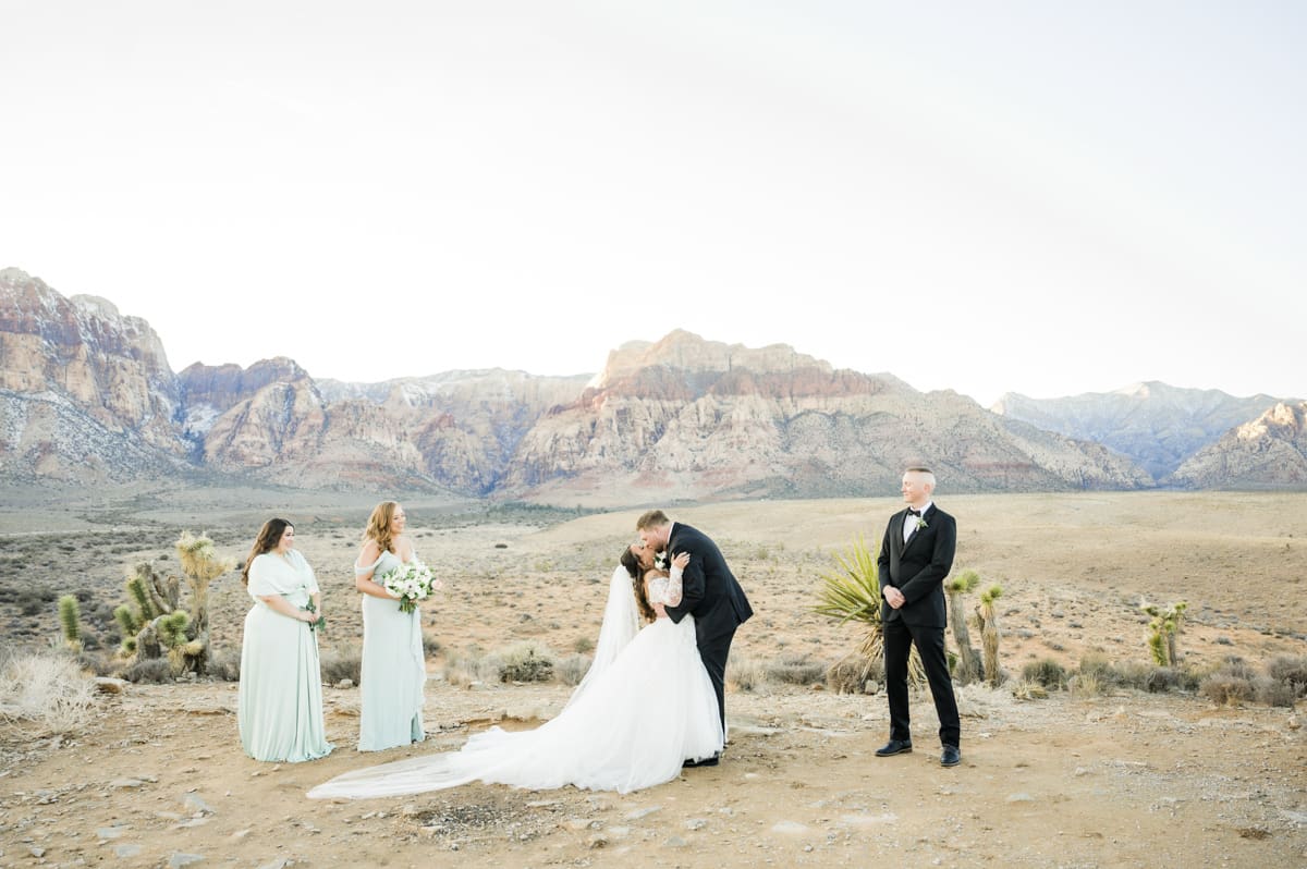 groom kisses bride at desert wedding
