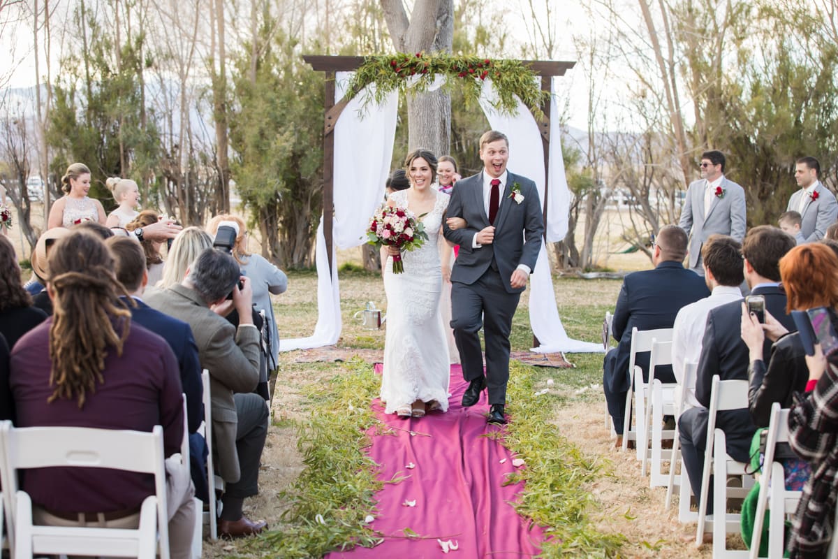 bride and groom walking back from alter with many guests looking on